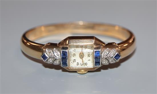 An Art Deco style 9ct gold, sapphire and diamond set bangle cocktail watch.